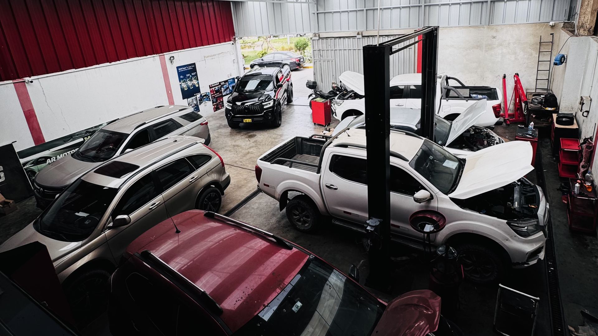 Interior del taller AR Motors en Trujillo, con vehículos en revisión